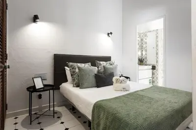 a bedroom with a large bed with a green blanket at Marina Club - Sea front - Vilamoura in Vilamoura