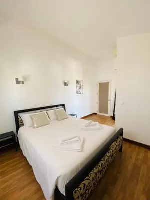 a bedroom with a large bed with white sheets at Duplex Marina de Vilamoura in Vilamoura