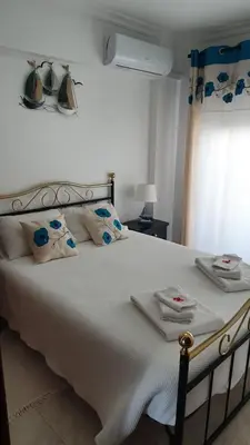 a bedroom with a large white bed with towels on it at Quarteira Beach in Quarteira