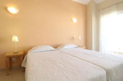 a bedroom with a white bed and a window at Lotus Villa V5 com piscina comum - Boliqueime, Algarve in Boliqueime