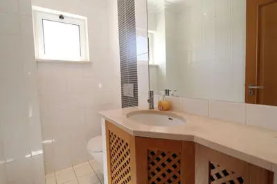 a bathroom with a sink and a toilet and a mirror at Lotus Villa V5 com piscina comum - Boliqueime, Algarve in Boliqueime