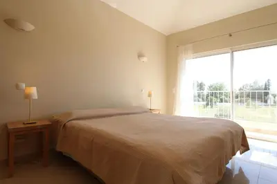 a bedroom with a bed and a large window at Lotus Villa V5 com piscina comum - Boliqueime, Algarve in Boliqueime