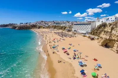 a beach with a lot of people and the ocean at Lotus Villa V5 com piscina comum - Boliqueime, Algarve in Boliqueime