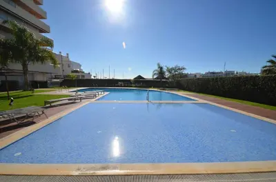 a large blue swimming pool in a building at Marina Vilamoura Aquamar 220 By Vilamoura Sun in Quarteira