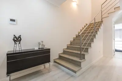 a staircase in a white room with a black dresser at D_Loft Ocean in Albufeira
