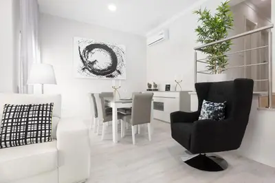 a white living room with a chair and a table at D_Loft Ocean in Albufeira