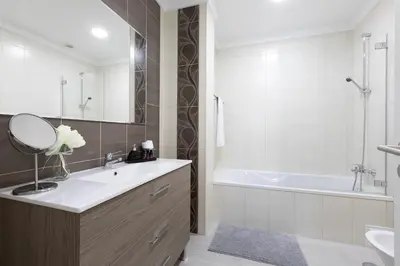 a bathroom with a sink and a tub and a mirror at D_Loft Ocean in Albufeira