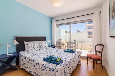 a bedroom with a bed and a large window at Garden Design in Albufeira
