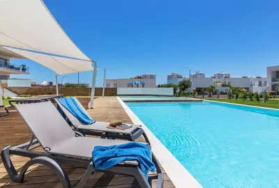 a lounge chair next to a swimming pool at Garden Design in Albufeira