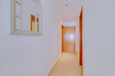 a hallway with a window and a door at Casa Luz - Quarteira in Quarteira