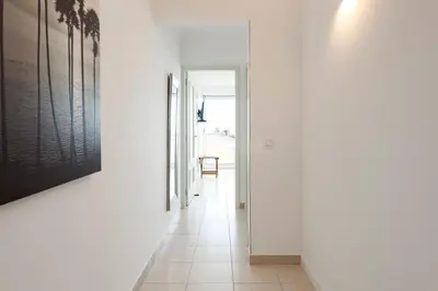 a hallway with white walls and white tile floors at Moura Suites III - Relaxing view - Vilamoura HD Properties in Vilamoura