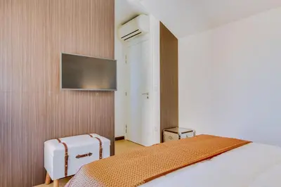 a hotel room with a bed and a flat screen tv at Gold II - Luxurious apartment - Vilamoura in Vilamoura