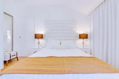 a white bedroom with a large bed and two lamps at Gold II - Luxurious apartment - Vilamoura in Vilamoura