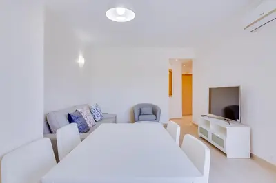 a white room with a white table and chairs at Tália I - City Center - Vilamoura in Vilamoura