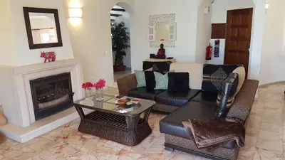 a living room with a couch and a fireplace at Villa Navita in Loulé