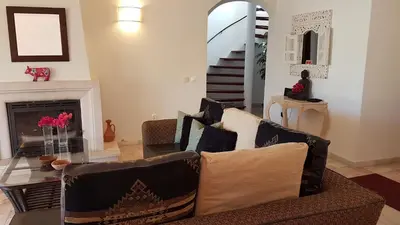 a living room with a couch and a fireplace at Villa Navita in Loulé