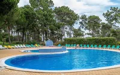 a large swimming pool with chairs and umbrellas at CAROB APARTMENT - BY MAYORAL (FALÉSIA BEACH) in Olhos de Água