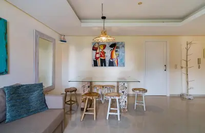a living room with a table and stools at CAROB APARTMENT - BY MAYORAL (FALÉSIA BEACH) in Olhos de Água
