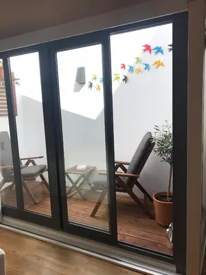 a room with sliding glass doors with a rocking chair at Porta 20 in Loulé