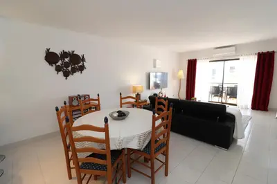 a living room with a table and a couch at Apt T2 Praia São Rafael Hibiscus 18A - Albufeira, Algarve in Albufeira