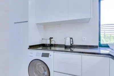 a white kitchen with a washing machine in it at Tália II - City Center - Vilamoura in Vilamoura