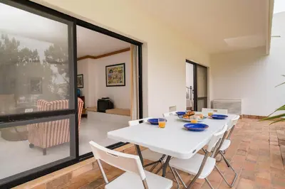 a dining room with a white table and chairs at BmyGuest - Quinta do Lago Garden Apartment in Almancil