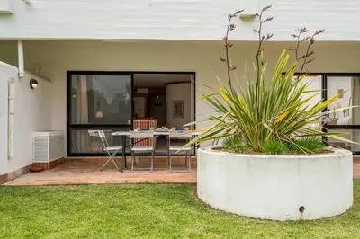 a house with a patio with a table and chairs at BmyGuest - Quinta do Lago Garden Apartment in Almancil