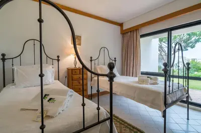 two beds in a room with a window at BmyGuest - Quinta do Lago Garden Apartment in Almancil