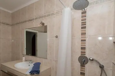 a bathroom with a sink and a shower with a mirror at Boas-Vindas in Albufeira
