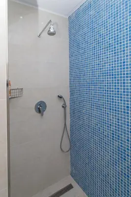 a bathroom with a shower with a blue tiled wall at Boas-Vindas in Albufeira