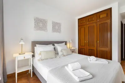 a bedroom with a white bed with two towels on it at Vilamoura - Cozy and Quiet Holiday Apartment in Vilamoura