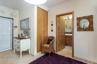 a bathroom with a chair and a table and a mirror at Decor n' cozy place for families and friends in Guia