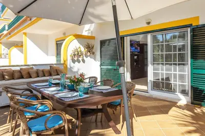 a table with chairs and an umbrella on a patio at Decor n' cozy place for families and friends in Guia