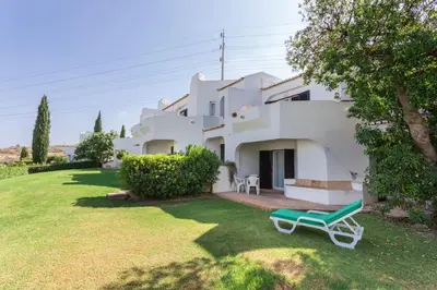 a table and chairs with an umbrella on a balcony at Albufeira Sunny Home for Families in Albufeira