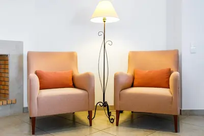 two chairs and a floor lamp in a room at Falésia Beach Villa by The Portuguese Butler in Olhos de Água