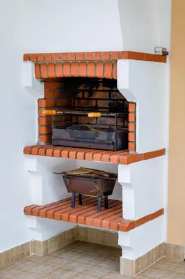 a brick fireplace in a white room with a brick at Falésia Beach Villa by The Portuguese Butler in Olhos de Água