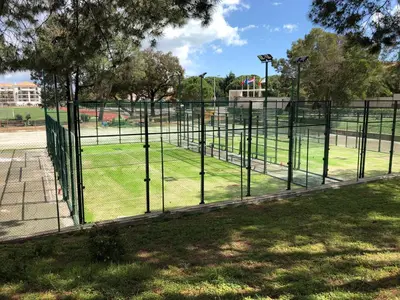 a fence in a park with a field of grass at Epic Falésia Apartment by The Portuguese Butler in Olhos de Água