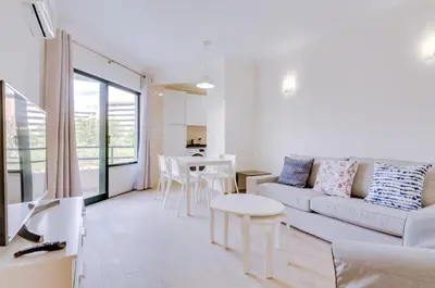 a living room with a couch and a table at Tália IV - City Center - Vilamoura in Vilamoura