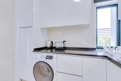 a white kitchen with a washing machine in it at Tália IV - City Center - Vilamoura in Vilamoura