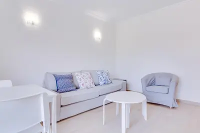 a living room with a couch and a chair and a table at Tália IV - City Center - Vilamoura in Vilamoura