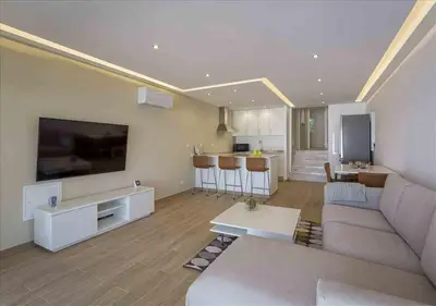 a living room with a couch and a large tv at Vicky Rae Beach House - Vale do Lobo in Almancil