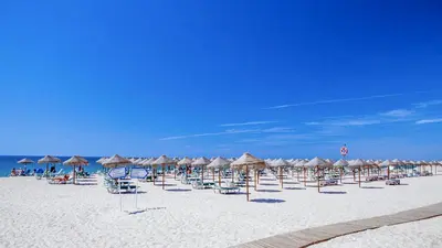 a group of beach chairs and umbrellas on a beach at Vicky Rae Beach House - Vale do Lobo in Almancil