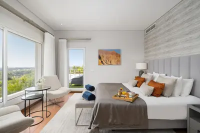 a bedroom with a large bed with a table on it at Villa Mebahel - Boliqueime in Boliqueime