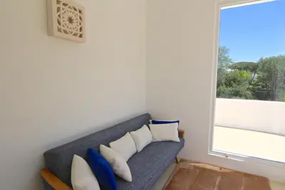 a blue couch with pillows in a room with a window at Villa Azul - Clever Details, Luxury villa, private pool, access to a club with tennis court, playground, communal pools in Vilamoura