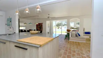 a kitchen with a counter top and a living room at Villa Azul - Clever Details, Luxury villa, private pool, access to a club with tennis court, playground, communal pools in Vilamoura