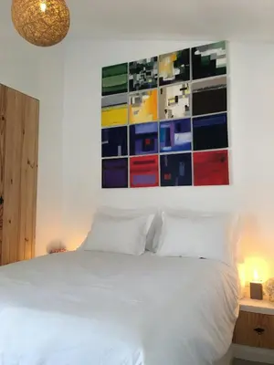 a bedroom with a white bed with a painting on the wall at Algarve Beach House with Heated Pool and Jacuzzi in Albufeira