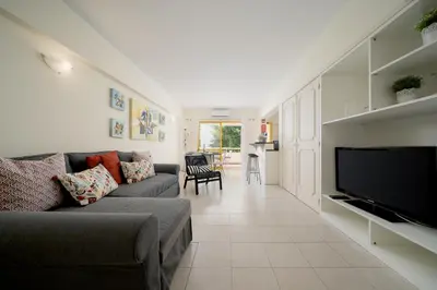 a living room with a couch and a flat screen tv at AL - R&R Vilamoura Flat, City Center in Vilamoura