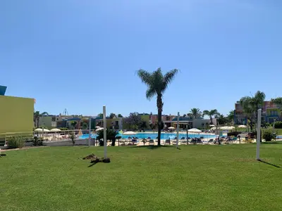 a park with a palm tree and a swimming pool at Penthouse 160sqm wide Terraces Pool view & private Hot Tub & Parking in Albufeira