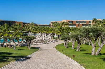 a path through a park with trees and a building at Apartamentos Vila das Lagoas – Salgados in Guia