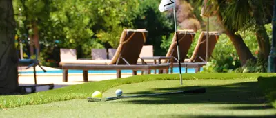 a golf ball and clubs on the grass with chairs at Casa Roma in Almancil